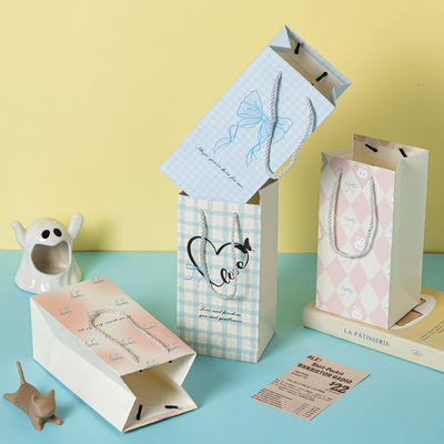 Buen precio Bolsa de papel de regalo exquisita de dibujos animados, bolso de mano con impresión de patrón personalizado, bolsa de cartón en línea